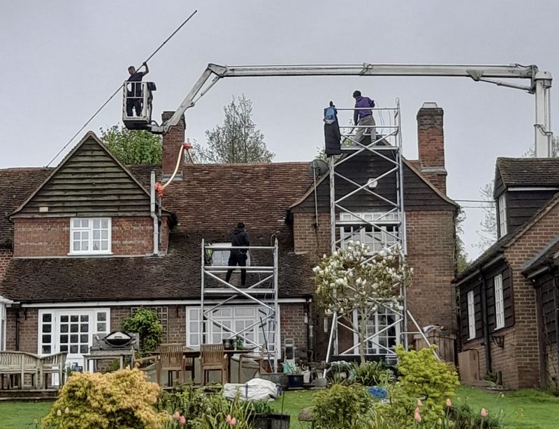 The Moss Cleaners using cherry picker and scaffolding to clean roof safely and professionally in Epsom, Surrey